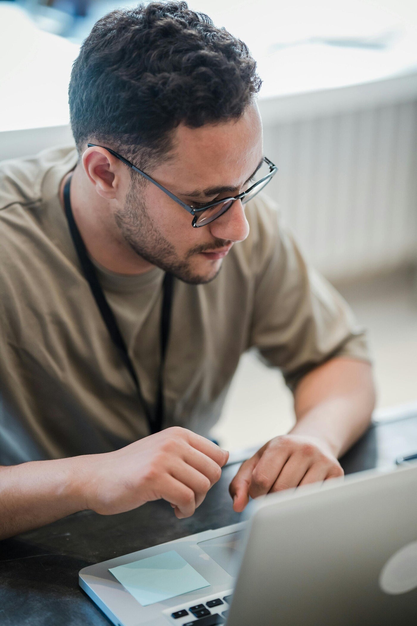Medewerker met bril werkt aan een laptop