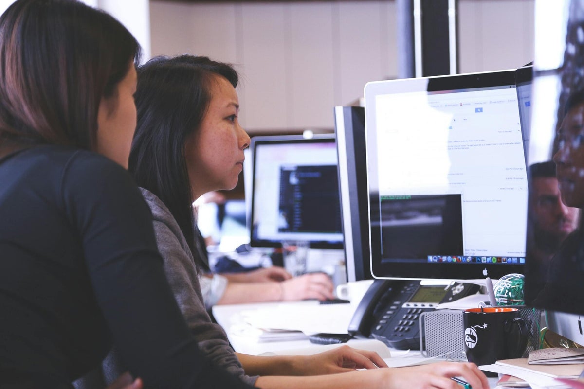 Twee collega's werken samen achter een computer